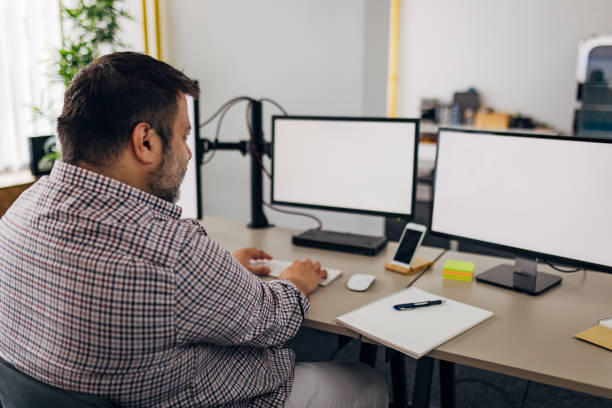 istock Back view of a concentrated businessman working at computer in office 1498126409