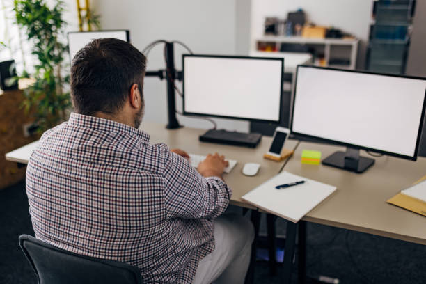 istock Back view of a focused businessman working at computer in office 1498126412