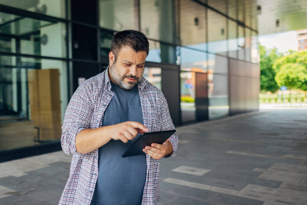 istock An IT professional uses a digital tablet while standing in front of the company where he works 1498126850