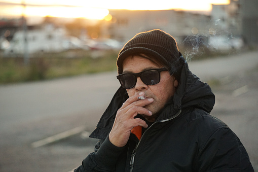 Portrait of a man smoking outdoors during winter
