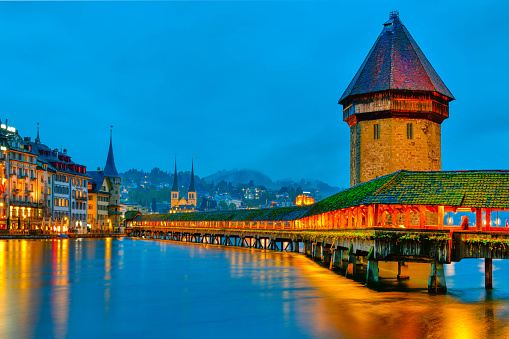 Beautiful historic city of Lucerne with famous Chapel Bridge and Water Tower at twilight time , Switzerland