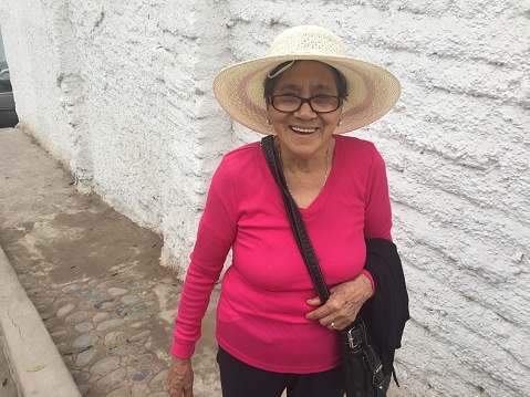 My mother smiling at me while walking up the streets on the footpath in Miraflores, Lima