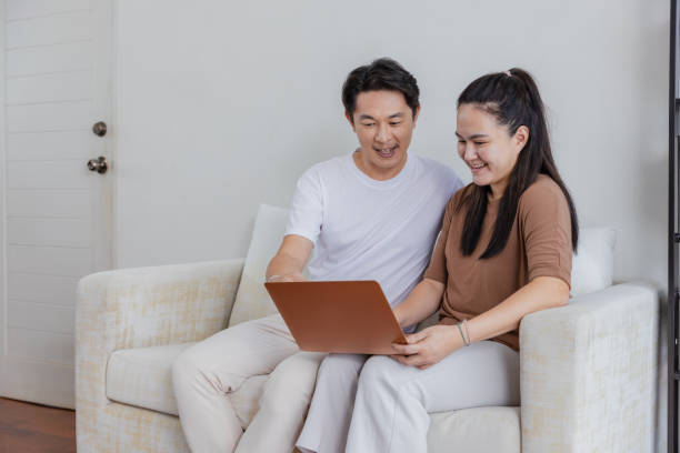 istock Couple talking and looking at computer together at home. 1498128990