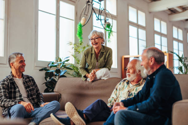 istock Four senior people talking and laughing while resting in living room. 1498129244