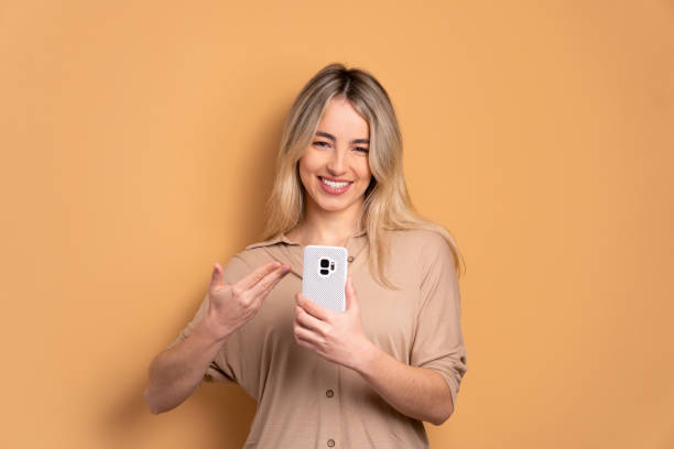 istock woman smiling and holding mobile phone 1498129949