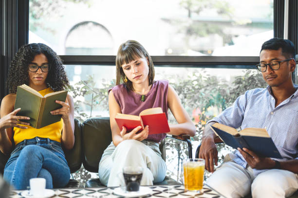 University, students and friends on cafeteria floor for studying, education and learning together, happy black girl, gen z youth and college student at academy, campus and school in room with bookshelf