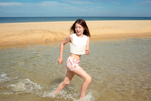Young girl  playing in the water at the edge of a lagoon