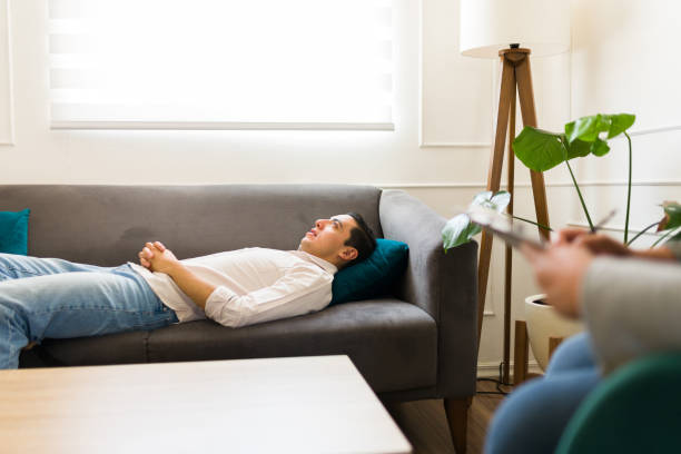 istock Depressed patient lying on the sofa during therapy 1498132124