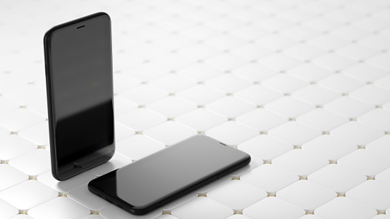 Two black smartphones with a blank black screen on the abstract white tile floor