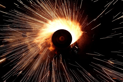 A metal object emitting bright sparks of fireworks in a dark and mysterious setting