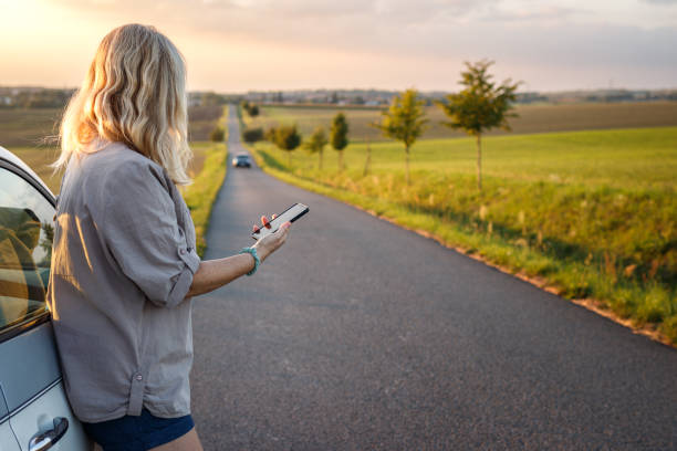 여름 로드 트립 동안 스마트폰을 사용하는 여성 - mirror car rural scene diminishing perspective 뉴스 사진 이미지