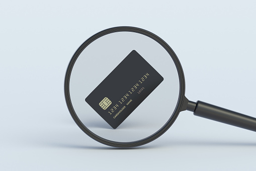 Credit card behind magnifying glass. 3d render