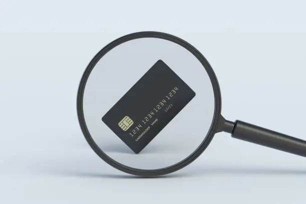 Photo of Credit card behind magnifying glass. 3d render