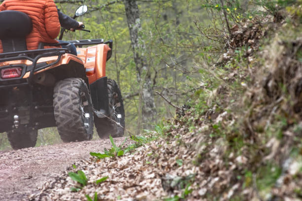 istock Driving an orange ATV on a forest-mountain road 1498142468