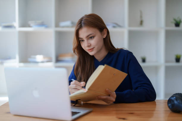 istock Happy latin girl college student watching distance online learning class, remote university webinar or having talk on laptop video call and use notebook to virtual meeting seminar at home or campus. 1498142473