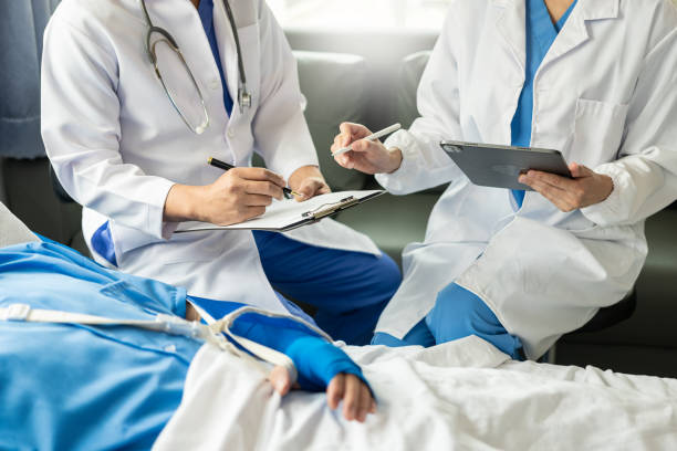 istock Two doctors talking to a patient lying in bed while receiving saline solution in hospital Professional medical service concept Attentive doctor comforting a patient Stock Picture 1498144982