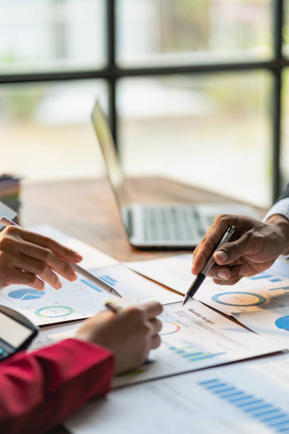istock Business team meeting using calculator Work with charts and analyze business strategies. financial statistics sitting at the desk vertical view 1498145202