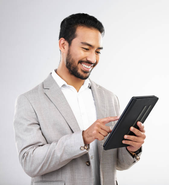 istock Smile, business and Asian man with tablet, typing and connection isolated on a white studio background. Japanese male ceo, employee and entrepreneur with device, scroll and network for online reading 1498145480