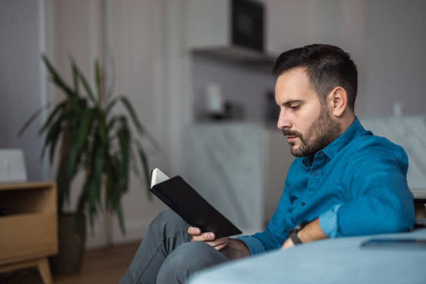 istock Serious man looking at notes in the notebook, sitting at the home office. 1498146829