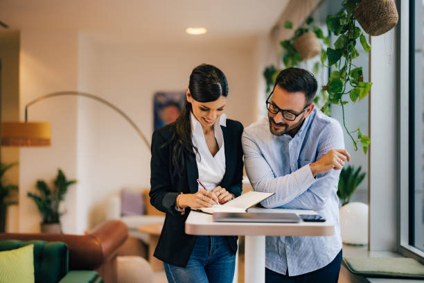 istock Two colleagues working together, reading notes in a notebook, standing at the office. 1498146869