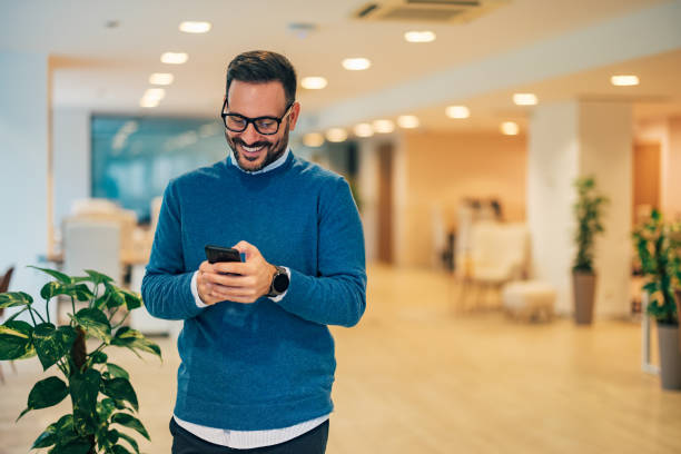 istock Smiling businessman texting a phone message taking a work break. 1498146934
