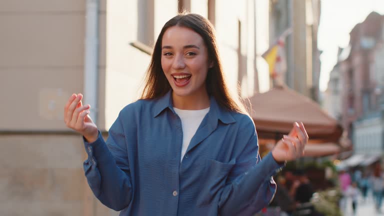 Cheerful rich woman showing wasting throwing money, win lottery, share, celebrate in city street