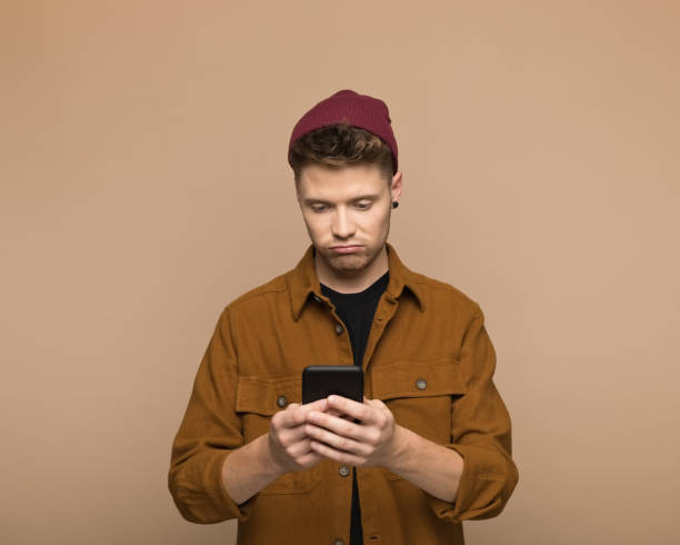 istock Displeased young man using smart phone 1498157665