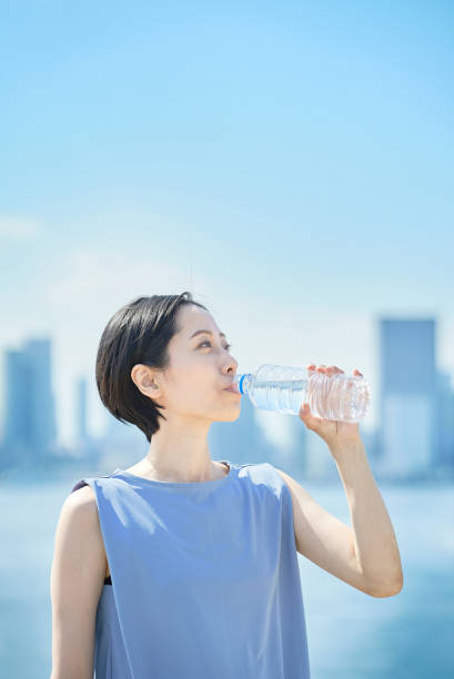 donna beve acqua da una bottiglia di plastica - water bottle healthy eating water bottle foto e immagini stock