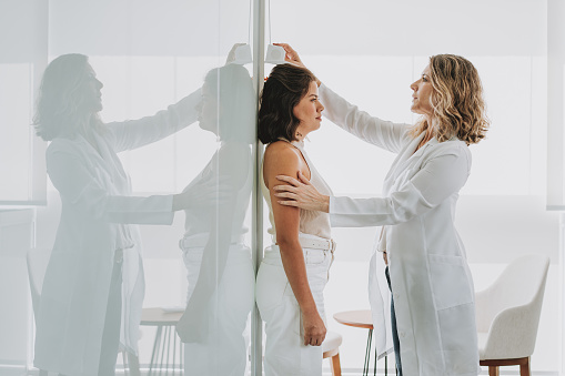Mujer midiendo la altura en el consultorio del médico photo