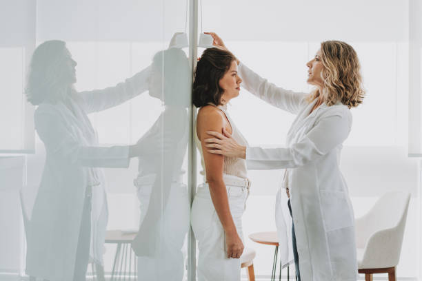 Woman measuring height at doctor's office Woman measuring height at doctor's office human height stock pictures, royalty-free photos & images