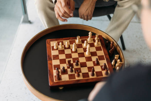 istock Focus On Chess Board And Friends Playing Chess 1498161643