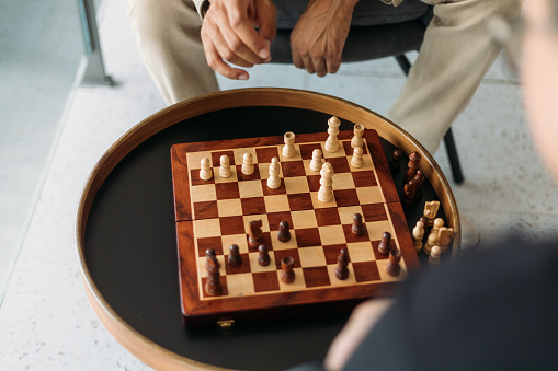 Close-up over the shoulder shot of African-American man playing chess with friend