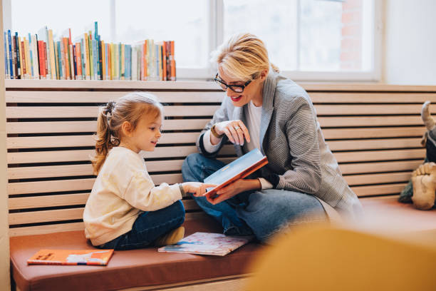 portret szczęśliwej matki i córki cieszących się czytaniem książek w bibliotece - law library school education zdjęcia i obrazy z banku zdjęć