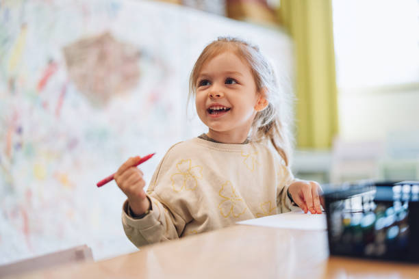 little girl drawing with markers at the nursery - happiness student cheerful lifestyle imagens e fotografias de stock