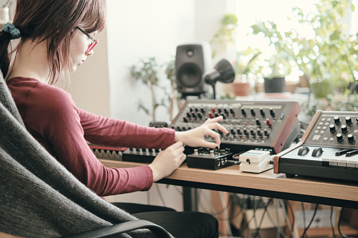 A teenage girl is learning to work with sound equipment