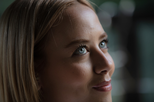 Blonde and turquoise / blue eyed woman headshot.