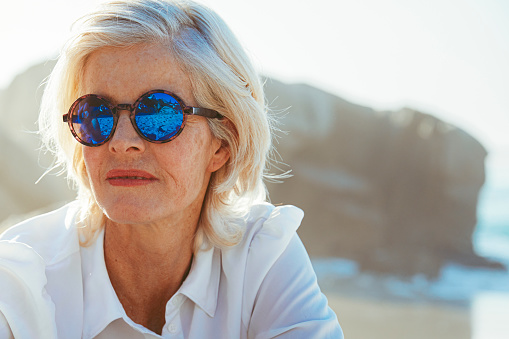Portrait of a fashionable and beautiful mature woman at the beach