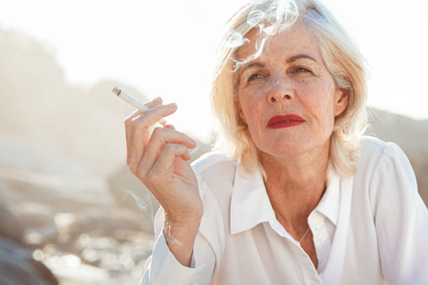 Giving up smoking is the easiest thing in the world. I know because I’ve done it thousands of times Portrait of a fashionable and beautiful woman at the beach, smoking smokers wrinkles stock pictures, royalty-free photos & images