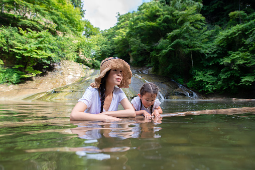 mother and daughter playing in the river