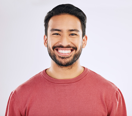 Happy, handsome and a headshot portrait of an Asian man isolated on a white background in studio. Smile, pride and a guy with confidence, happiness and attractive while smiling on a backdrop