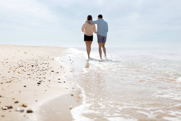 Man and woman in love walking by the beach