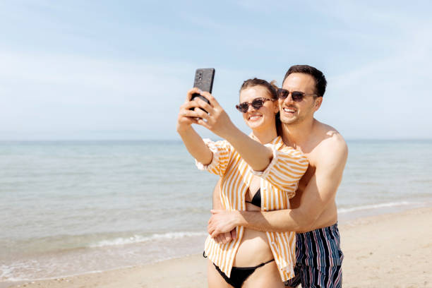 istock Couple in love taking a selfie on the beach 1498172561