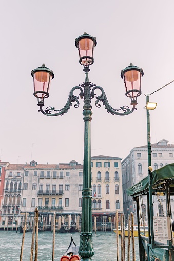 Lone lamp illuminates the pier, near which stands alone gondola.