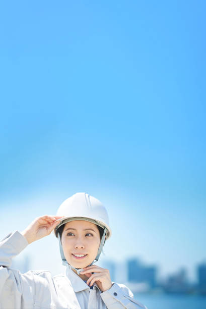istock A woman wearing work clothes and checking a helmet 1498174352