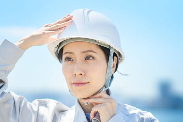istock A woman wearing work clothes and checking a helmet 1498174409
