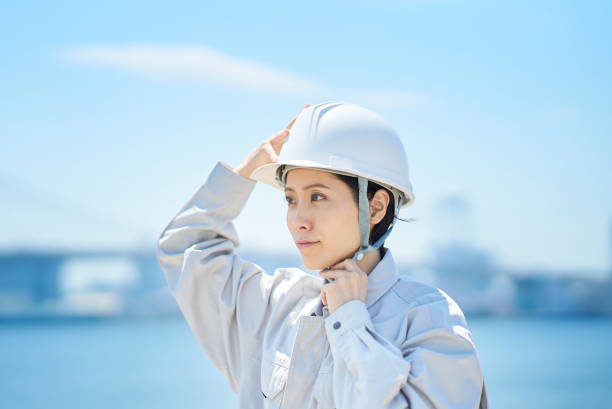 istock A woman wearing work clothes and checking a helmet 1498174559
