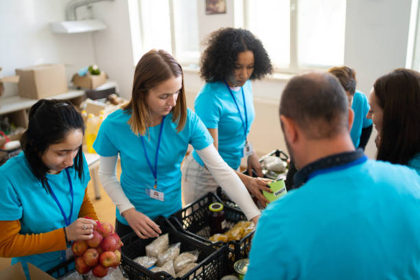 istock Group of multi-ethnic volunteers working in charitable foundation, packing donation boxes 1498174723