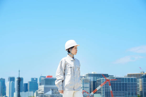 A woman wearing a helmet and wearing work clothes
