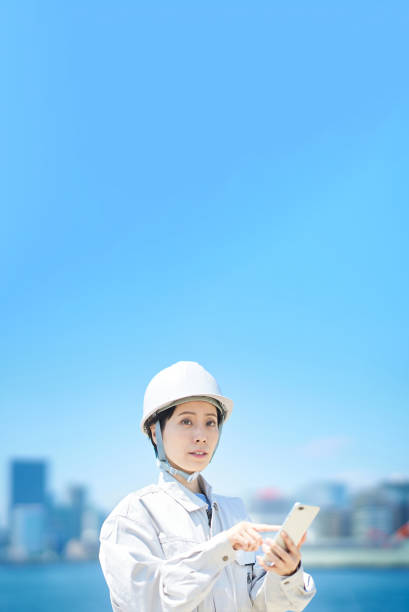 istock A woman in work clothes holding a smartphone 1498176376