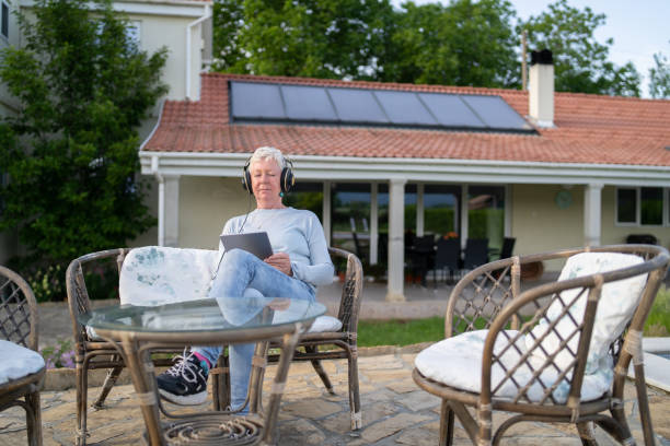 dojrzała dama słucha muzyki na słuchawkach - solar power station audio zdjęcia i obrazy z banku zdjęć